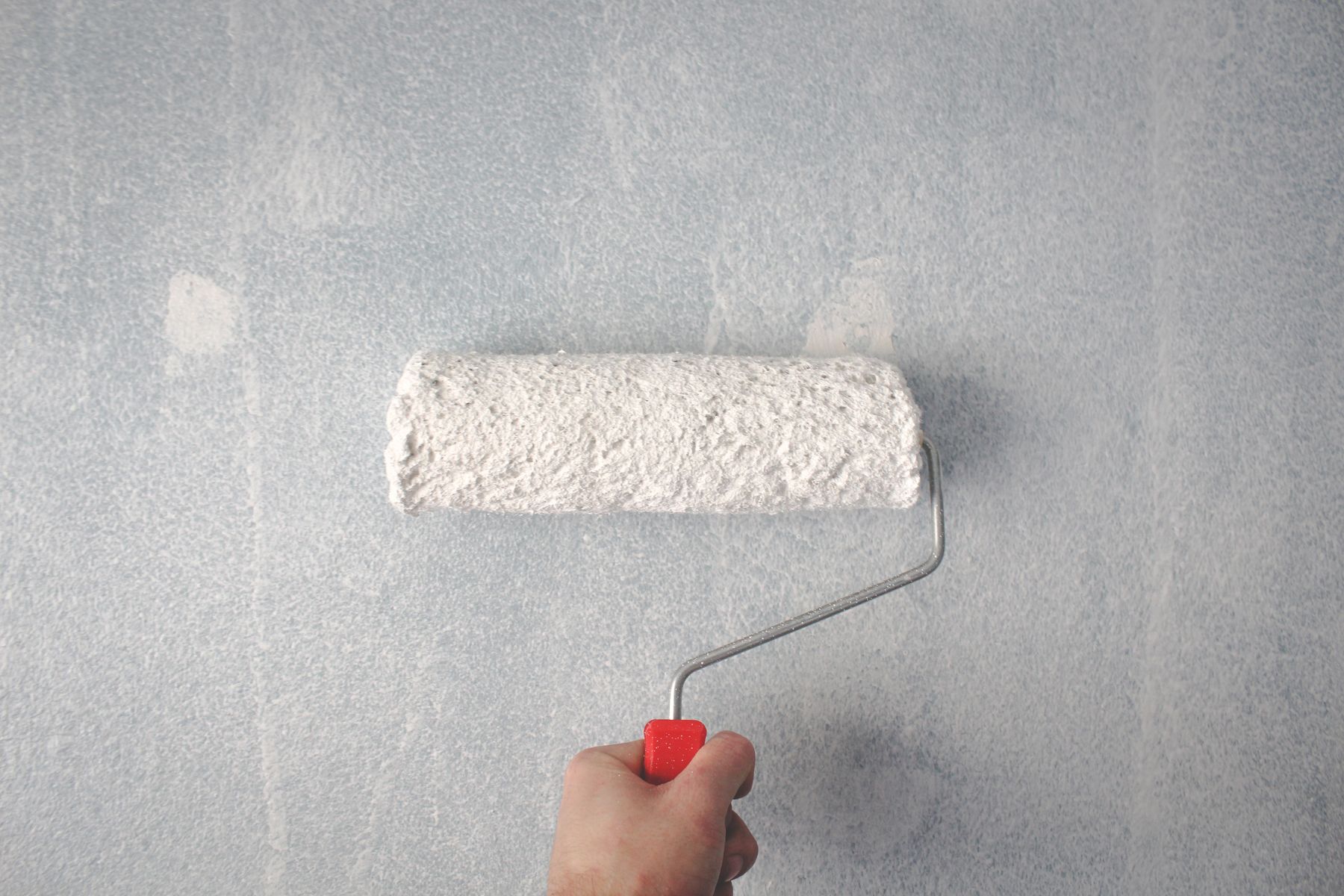 Painter rolling fresh paint onto an interior wall
